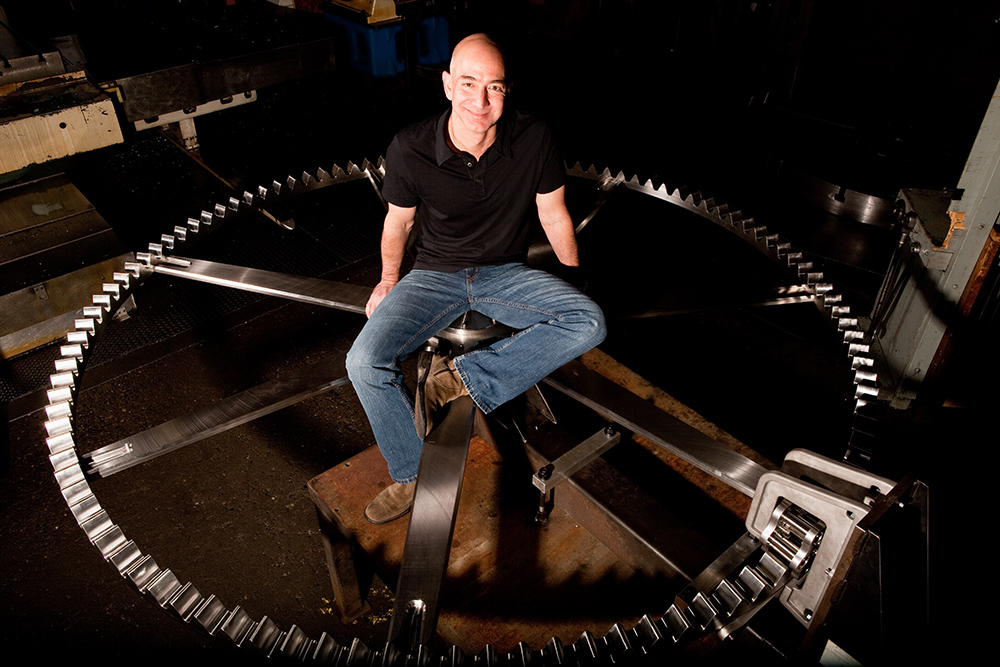 photo of Jeff Bezos sitting on a giant metal gear