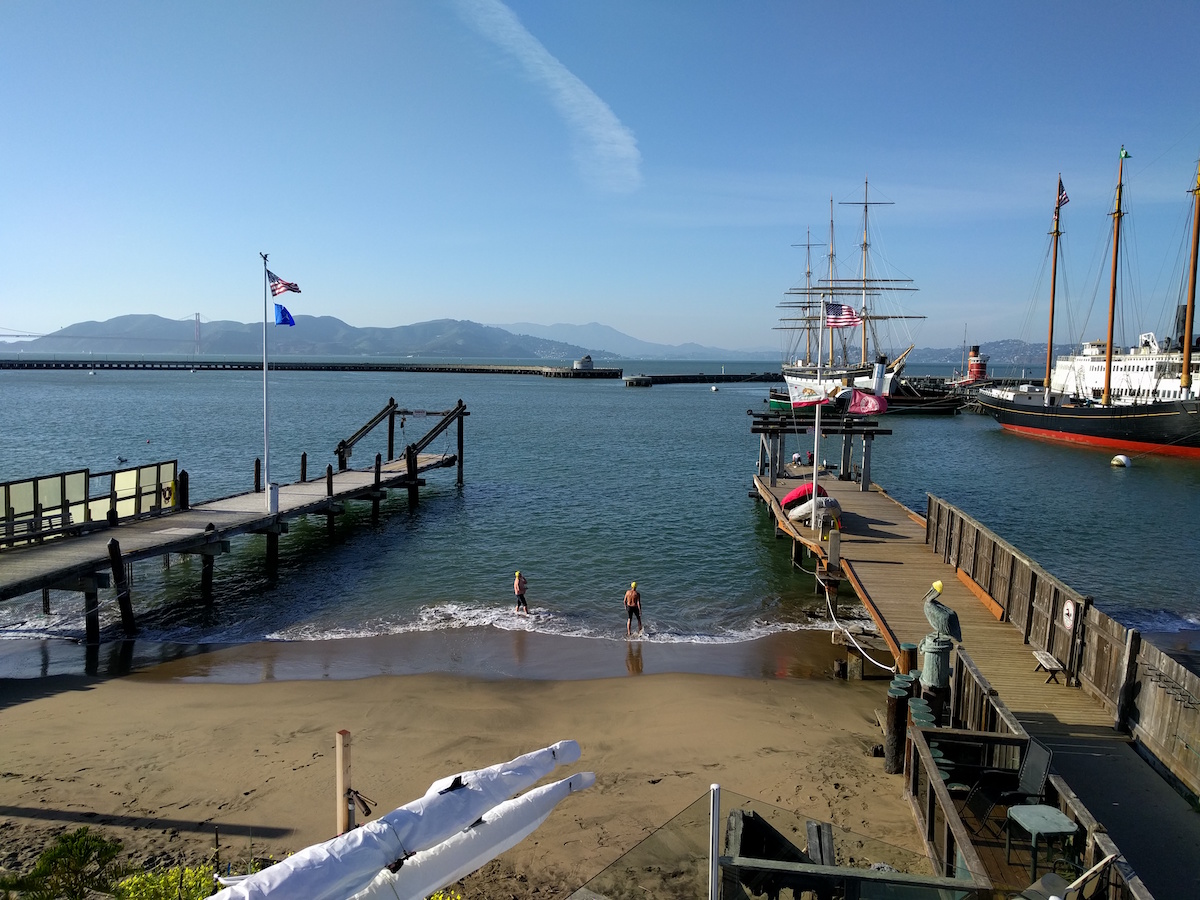 Picture of Aquatic Park cove showing two docks and a triple-masted schooner in the background